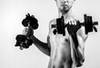 © Yevhen - A thin man in sports with dumbbells. Weak man lift a weight, dumbbells, biceps, muscle, fitness. Nerd maleraising a dumbbell. Black and white