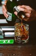 Vertical shot of a human hands pouring vermouth and soda in an ice glass
