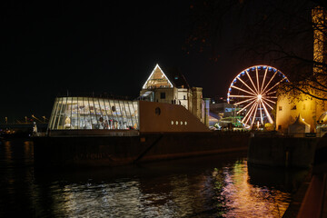 Wall Mural - Outdoor night scenery along riverside of Rhine river and background of Hafen Weihnachtsmarkt near Chocolate Museum during Christmas market in winter season. 