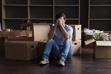 Wall Mural - Stressed frustrated former home owner leaving flat, apartment, sitting at mess of cardboard boxes on floor, covering face, feeling sad about new home search, eviction, divorce, bankruptcy