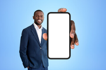 Poster - Smiling African American businessman standing holding smartphone