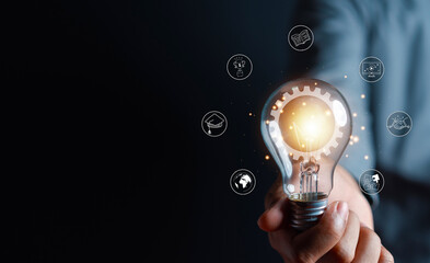 Fototapete - Man hand holding lightbulb with learning educate and graduation concept. study knowledge to creative thinking idea and problem solving solution, E-learning online education course degree certificate