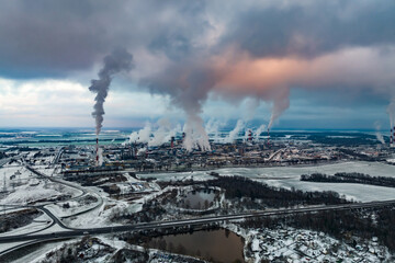 winter panoramic aerial view of the smoke of pipes of a chemical plant or woodworking enterprise. Air and water pollution concept.