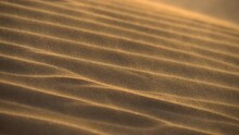 Wind Carries The Sand Along The Dune In The Desert. Slow Motion Shot Of Desert Sand Dunes Ripples In The Wind