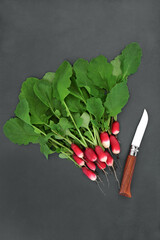 Wall Mural - Radish salad vegetables, organic freshly picked salad vegetables with knife. Sustainable healthy food and immune system boosting concept. High in antioxidants, anthocyanins, vitamins on grey slate.