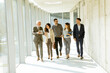 © BGStock72 - Group of corporate business professionals walking through office corridor