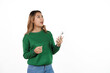 © NanSan - Attractive beautiful asian woman in green sweater isolated on white background. Use your mobile phone and feel happy to receive good news