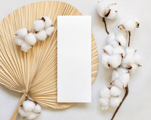 Wall Mural - Blank card on dried palm leaf with cotton flowers top view, wedding mockup