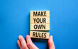 Make your own rules symbol. Concept words Make your own rules on wooden cubes. Beautiful blue table blue background. Businessman hand. Business motivational make your own rules concept. Copy space