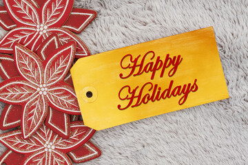 Wall Mural - Happy Holidays greeting on a gift tag with wood poinsettias