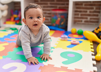 Wall Mural - Adorable hispanic baby crawling on floor at kindergarten