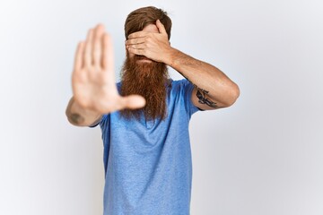 Sticker - Caucasian man with long bear standing over isolated background covering eyes with hands and doing stop gesture with sad and fear expression. embarrassed and negative concept.