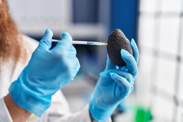 Canvas Print - Young redhead man scientist injecting liquid on avocado at laboratory