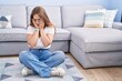 © Krakenimages.com - Young caucasian woman sitting on the floor at the living room with sad expression covering face with hands while crying. depression concept.
