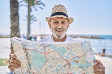 Canvas Print - Senior man smiling confident wearing summer hat holding map at seaside