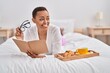 © Krakenimages.com - African american woman having breakfast reading book at bedroom