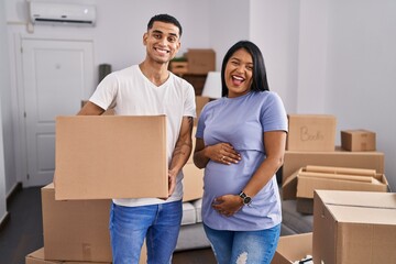 Poster - Young hispanic couple expecting a baby moving to a new home celebrating crazy and amazed for success with open eyes screaming excited.