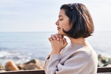 Young Woman Smiling Confident Praying At Seaside