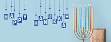 Menorah With Glowing Candles And Gift For Hanukkah On Light Blue Background