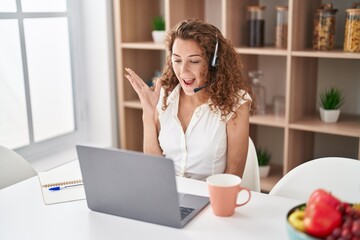 Sticker - Young caucasian woman wearing call center agent headset working from home screaming proud, celebrating victory and success very excited with raised arm