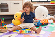 © Krakenimages.com - Adorable hispanic toddler playing xylophone sitting on floor at kindergarten