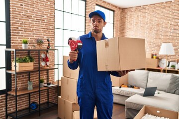 Poster - Young hispanic man working on moving service depressed and worry for distress, crying angry and afraid. sad expression.