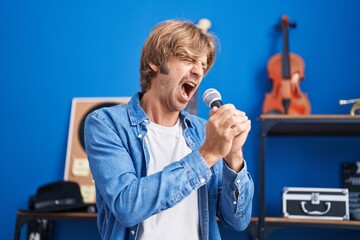 Wall Mural - Young man artist singing song at music studio