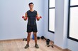 © Krakenimages.com - Young hispanic man smiling confident using dumbbells training at sport center