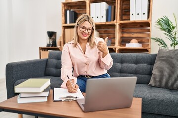 Poster - Young hispanic woman working online at consultation office smiling happy and positive, thumb up doing excellent and approval sign