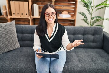 Sticker - Young beautiful hispanic woman psychologist smiling confident speaking at psychology clinic