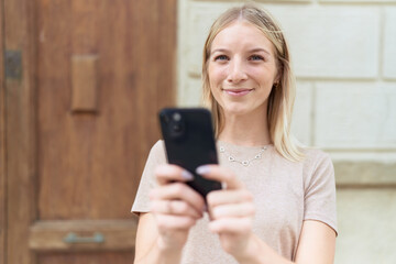 Sticker - Young blonde woman smiling confident using smartphone at street