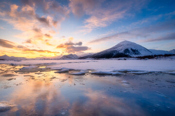 Wall Mural - north, norway. winter landscape during sunset. bright sky. ice and snow on the shore. reflections on