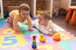 © Krakenimages.com - Two toddlers playing with toys sitting on floor at kindergarten