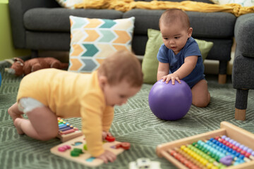 Wall Mural - Two toddlers playing with toys sitting on floor at home