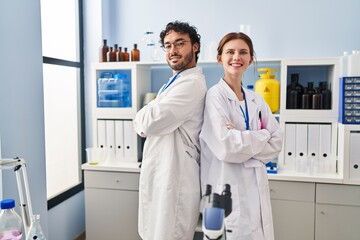 Sticker - Man and woman scientist partners standing with arms crossed gesture at laboratory