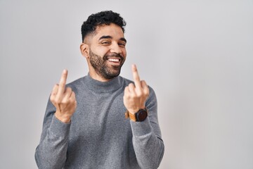 Canvas Print - Hispanic man with beard standing over white background showing middle finger doing fuck you bad expression, provocation and rude attitude. screaming excited