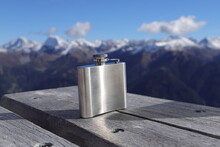 A Hip Flask On A Table In The Mountains