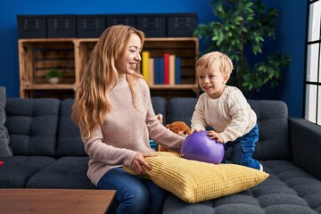 Sticker - Mother and son playing with ball sitting on sofa at home