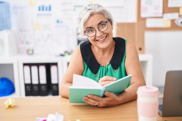 Canvas Print - Middle age grey-haired woman business worker reading book at office