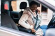 © Krakenimages.com - African american woman smiling confident fastening seat belt at street
