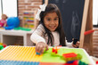 © Krakenimages.com - Adorable hispanic girl playing with construction blocks sitting on table at kindergarten