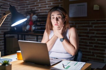 Wall Mural - Brunette woman working at the office at night shouting and suffocate because painful strangle. health problem. asphyxiate and suicide concept.