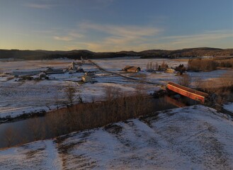 Canvas Print - Aerial view of houses and rivers in rural area covered with snow during winter