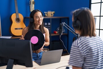 Poster - Two women musicians listening to music holding vinyl disc at music studio