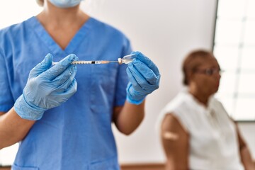 Poster - Senior african american woman patient having vaccination at clinic