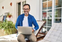 Middle Age Man Smiling Confident Using Laptop At Terrace Home