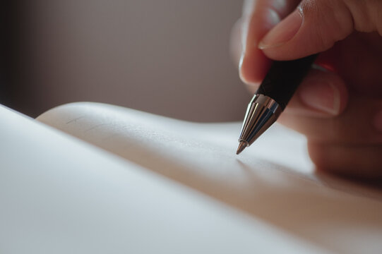 female hand close-up writes with a pen in a blank notebook.she writing a daily lifetime.business wom