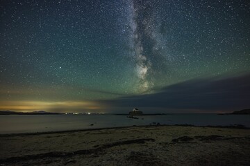 Wall Mural - Milky Way and night sky over St Cwyfans Church at Anglesey, Wales