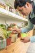 © ADDICTIVE STOCK - Male gardener pouring soil into pot