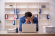 © Elnur - Young male employee and too much work in the office